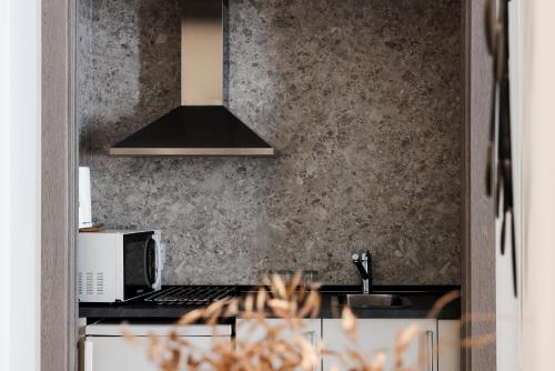 a kitchen with a stove and a microwave at Suite Prado in Madrid