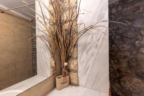 a bathroom with a vase with some grass in it at Avgi's House Pelekas in Pelekas