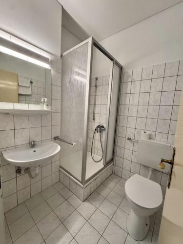 a bathroom with a shower and a toilet and a sink at Kurhaus im Harz - Bad Harzburg in Bad Harzburg
