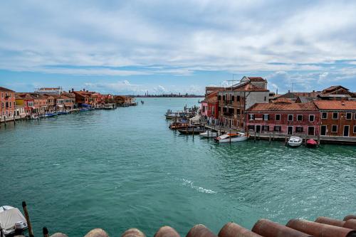 a view of a river with buildings and boats at Hyatt Centric Murano Venice in Murano