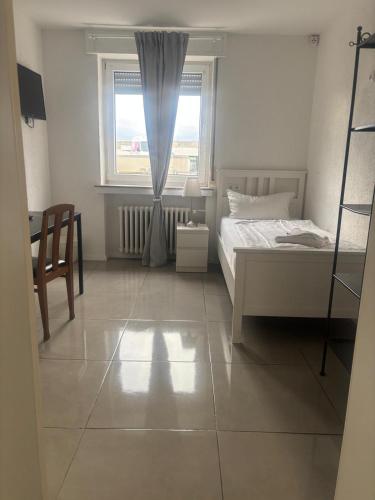 a bedroom with a bed and a window and a chair at GZ Hostel Bonn in Bonn