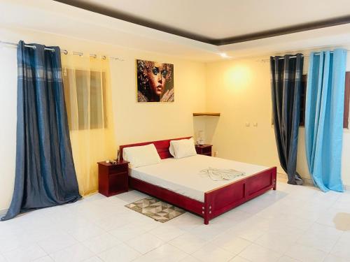 a bedroom with a large bed with blue curtains at Bulle d'Or PREMIUM in Libreville
