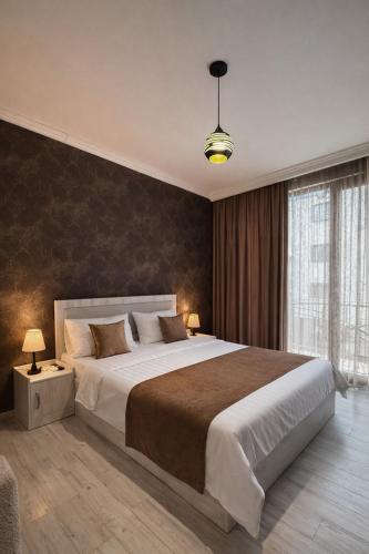 a bedroom with a large bed and a large window at Urban Nest old Tbilisi hotel in Tbilisi City