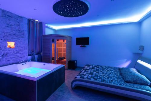 a room with a bed and a bath tub at LX202 Love Room & Spa privatif - Jacuzzi & Sauna in Dijon