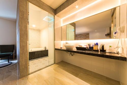 a bathroom with a counter with a sink and a tub at Boutique Hotel SB Yeouido in Seoul