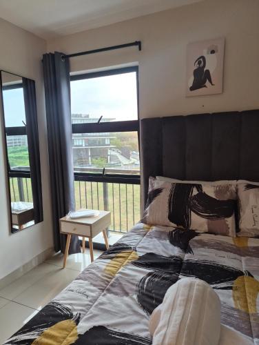 a bedroom with a bed and a large window at Tettey Haven Millennial in Durban