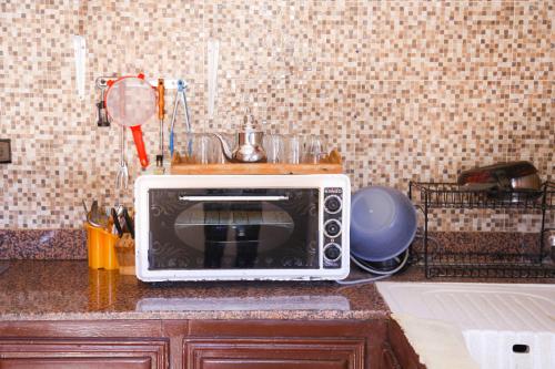 a microwave sitting on top of a kitchen counter at maison avec deux chambres climatisées in Er Rachidia