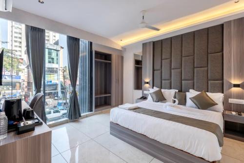 a bedroom with a large bed and a large window at Hotel Hycon in Kozhikode