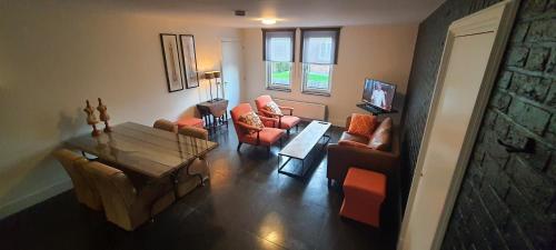 a living room with orange chairs and a table at B&B Velddriel in Velddriel