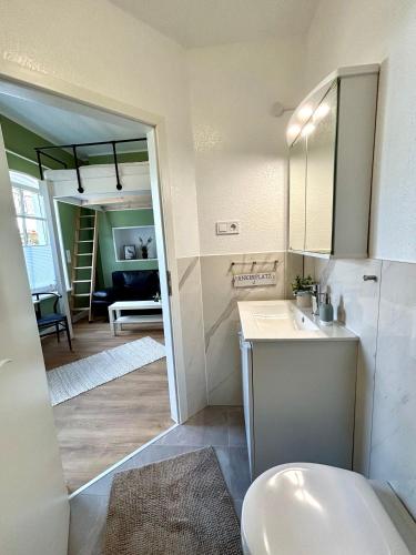 a bathroom with a sink and a toilet in a room at Haus OstseeWelle - Kleine Perle in Dahme