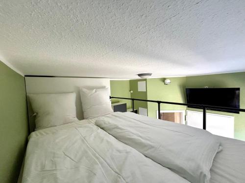 a large white bed in a room with a flat screen tv at Haus OstseeWelle - Kleine Perle in Dahme