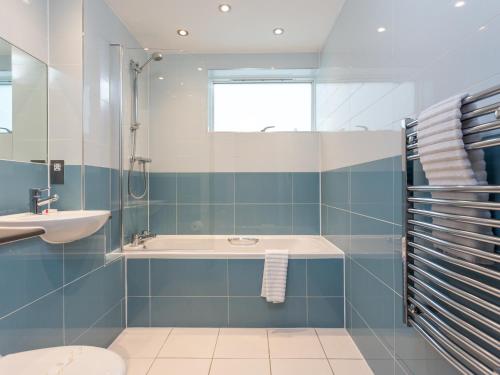 a bathroom with a shower and a sink and a tub at Curlew in Poole