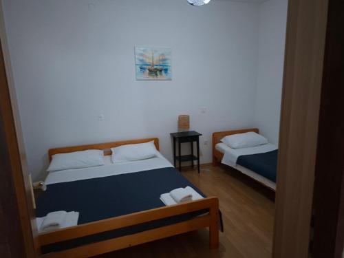 a bedroom with two beds and a table with a mirror at Apartments Mara Mandre in Mandre