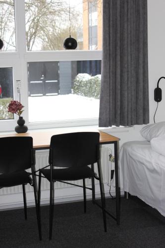 a bedroom with a desk and two chairs in front of a window at Vildbjerg Sports Hotel & Kulturcenter in Vildbjerg