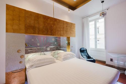 a bedroom with a large white bed and a chair at Hotel Trecento in Rome