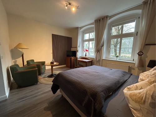 a bedroom with a bed and a desk and window at Schloss Spiegelberg in Neustadt