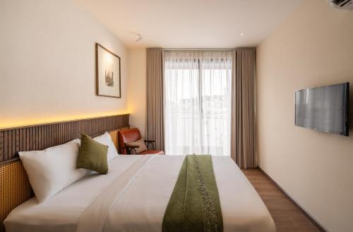 a hotel room with a bed and a television at Saigon Maison 1988 BUI VIEN Centre in Ho Chi Minh City