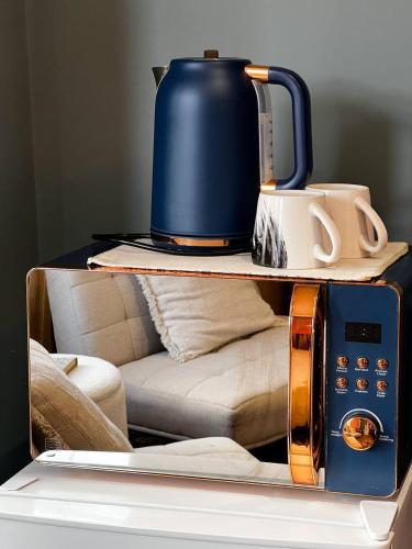 a tea kettle and a toaster on top of a table at Zozy Anson in London