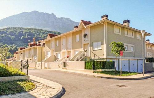 a building on a street with a mountain in the background at Chalet adosado con piscina en el Valle de Asón LA TUDANCA in Arredondo