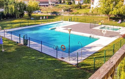 a large swimming pool with a fence around it at Chalet adosado con piscina en el Valle de Asón LA TUDANCA in Arredondo