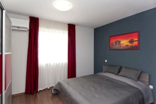 um quarto com uma cama e uma janela com cortinas vermelhas em Sofia Top Lux Apartment em Sófia