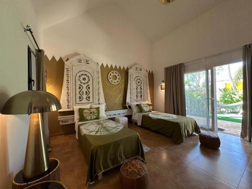 a hotel room with two beds and a lamp at ADWO Lodge in Ngaring