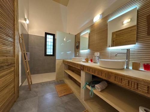 a bathroom with two sinks and a large mirror at ADWO Lodge in Ngaring