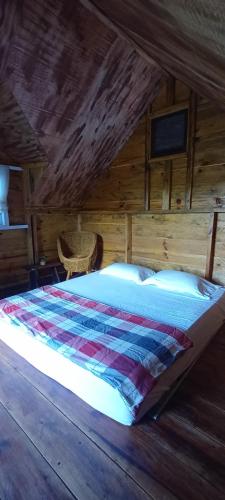 a bedroom with a bed in a wooden cabin at JE House in Ambarita