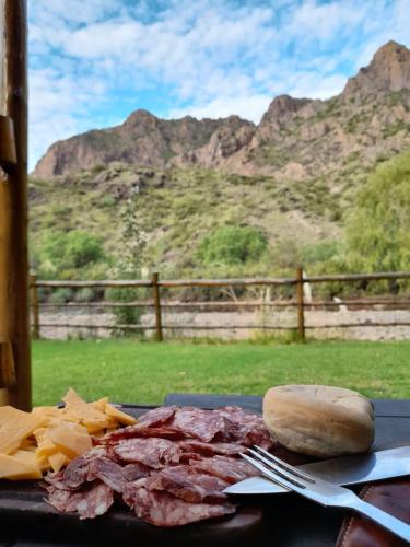 a piece of meat and chips on a table with a sandwich at Cabaña Cerro Lindo in San Rafael