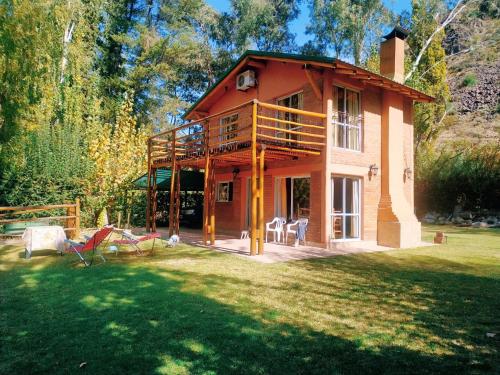 a large house with a balcony and a yard at Cabaña Cerro Lindo in San Rafael