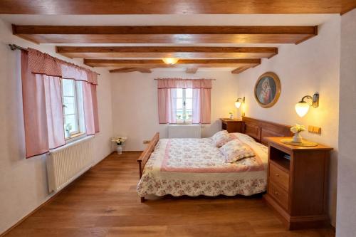 a bedroom with a bed and two windows at U Bílého koníka in Kostelní Bříza