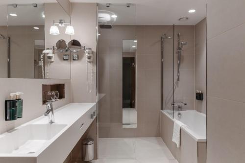 a bathroom with two sinks and a shower at Clarion Hotel Arlanda Airport Terminal in Arlanda