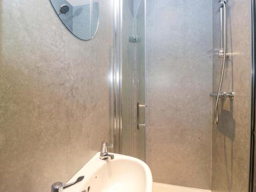 a bathroom with a sink and a shower with a mirror at Havelock Hideaway in Windermere