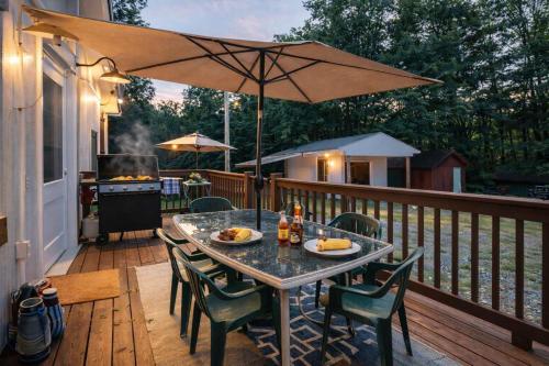 a table and chairs on a deck with an umbrella at Rough River Lake Hideaway Your Lakeside Escape in Fentress McMahan