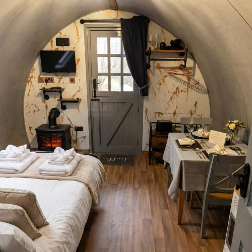 a room with two beds and a table and a window at Caplor Glamping & Lodges in Hereford