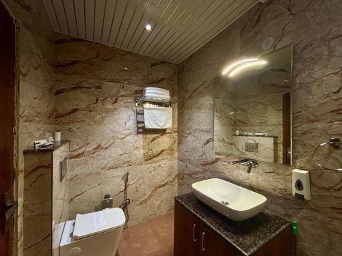 a stone bathroom with a sink and a toilet at Vyom Boutique Hotel by Aramah in Rishīkesh