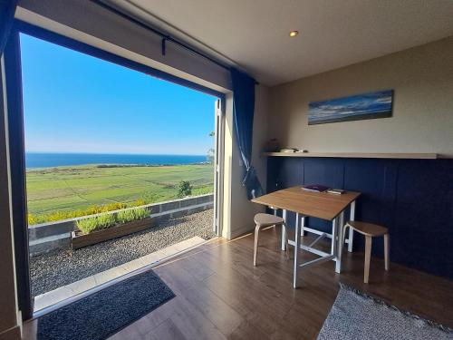 a dining room with a table and a large window at Lothmore Lookout - Sunset in Kilmote