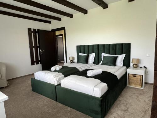 a bedroom with two beds with white and green at Refugiul Domnitei in Bran