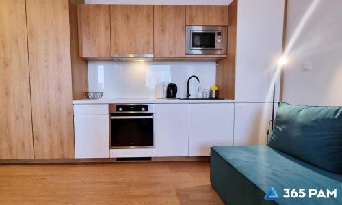 a small kitchen with a stove and a microwave at 365PAM - Prywatne apartamenty w hotelu in Sarbinowo