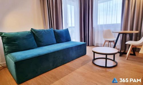 a living room with a green couch and a table at 365PAM - Prywatne apartamenty w hotelu in Sarbinowo
