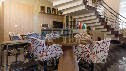 a room with a table and chairs and stairs at Grande Hotel Ipatinga in Ipatinga