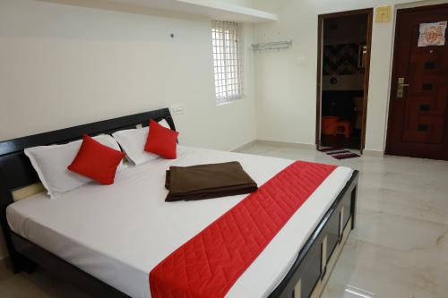 a bedroom with a large bed with red pillows at Mercury JKR Residency in Yelagiri