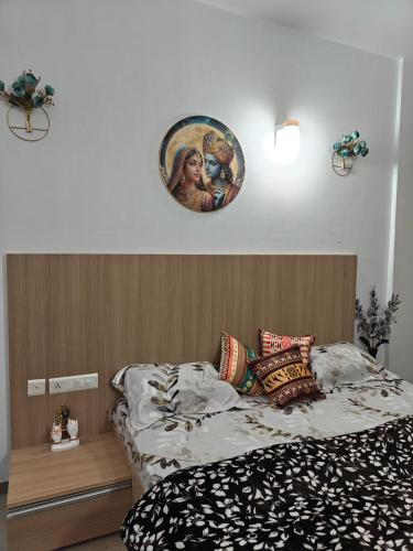 a bedroom with a bed with a picture on the wall at Shivaya Homes in Chhatikara