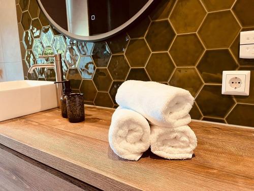 a stack of towels sitting on a counter in a bathroom at Luxe appartement 4 personen #2