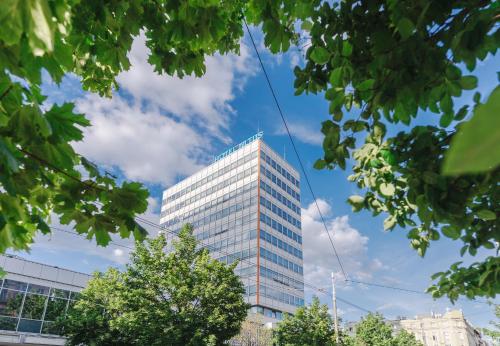 a tall glass office building against a blue sky at Hotel Altus Poznań Old Town - Destigo Hotels in Poznań