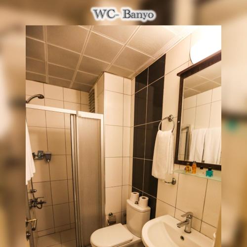 a bathroom with a toilet and a shower and a sink at Boğaz Otel in Çanakkale