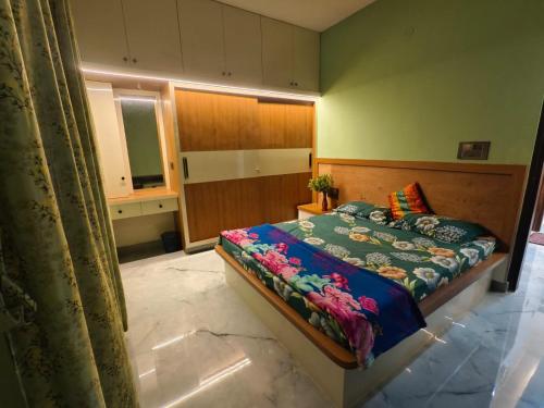 a bedroom with a bed in a room with a mirror at Tranquil service apartment in Chikmagalūr