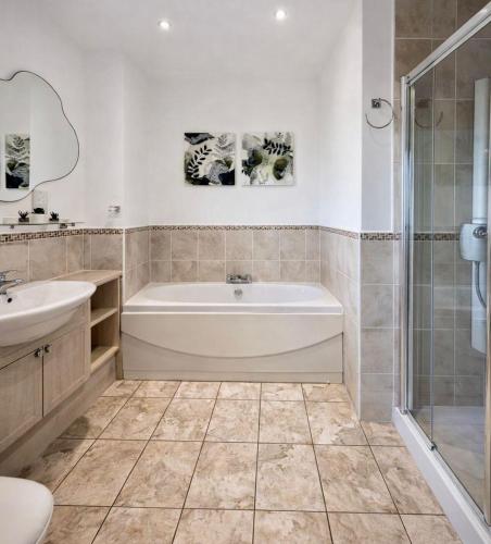 a bathroom with a tub and a sink and a shower at BraeView House in Inverness