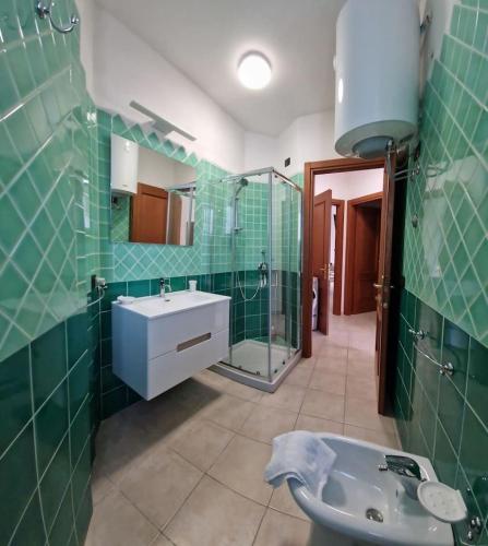 a green tiled bathroom with a sink and a shower at Centrale! Comodo appartamento a Palau con parking! in Palau