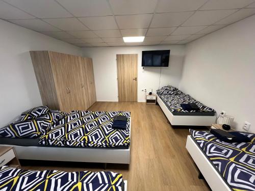 a room with two beds and a flat screen tv at Apartmány Škodova Přerov in Přerov